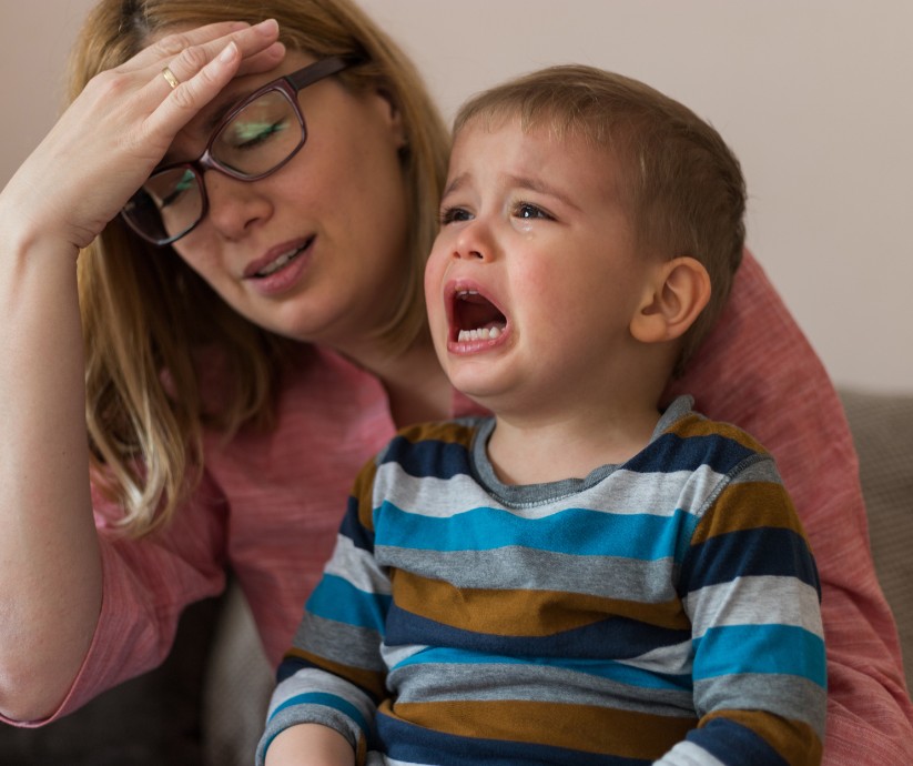 Jongetje in peuterpubertijd huilen, moeder verliest geduld